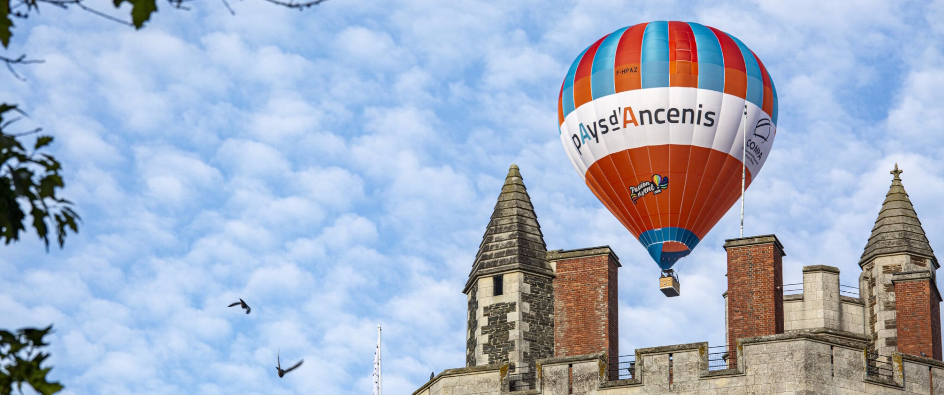 Montgolfière au-dessus d'un bâtiment historique.