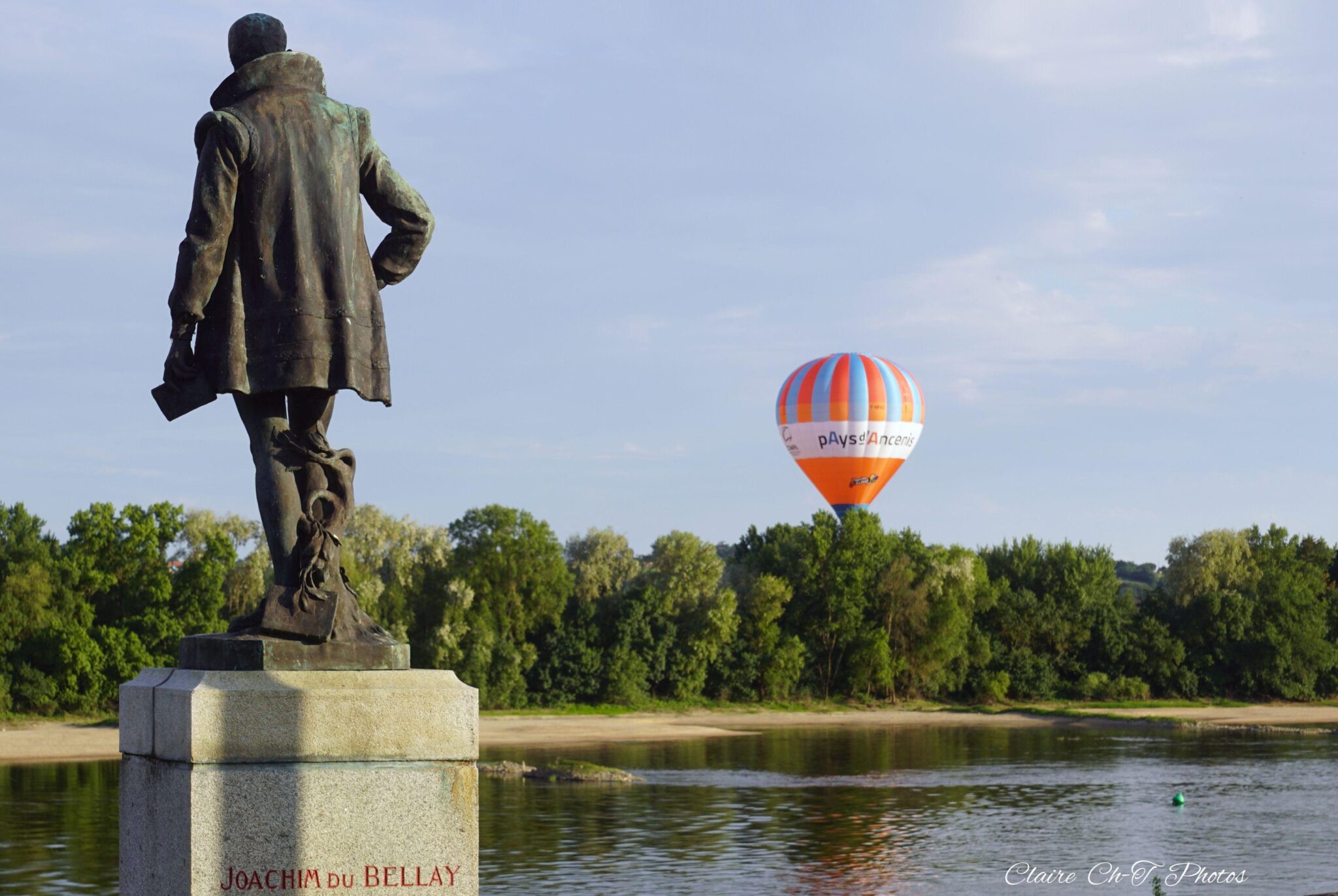 Statue et montgolfière au-dessus d'une rivière
